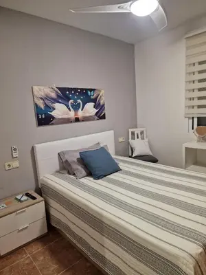 a bedroom with a large bed with a blue pillow at Habitaciones Zoe in Puerto de Sagunto