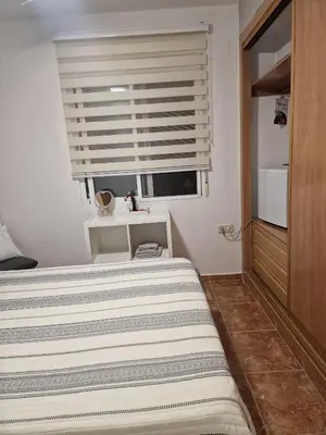 a bedroom with a bed and a window with a sink at Habitaciones Zoe in Puerto de Sagunto