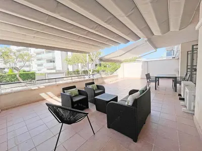 an outdoor patio with chairs and tables and a roof at Global Vacacional, Apartamento con gran terraza en Canet in Canet de Berenguer