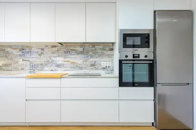 a white kitchen with a refrigerator and a microwave at Un endroit accueillant avec vue à Jerica in Jérica