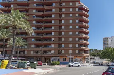 a tall building with palm trees in front of it at Faromar, I-10-M in Cullera