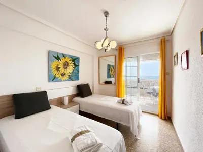 a room with two beds and a window at Global Vacacional, Apartamento en primera línea de playa, Canet de Berenguer in Canet de Berenguer