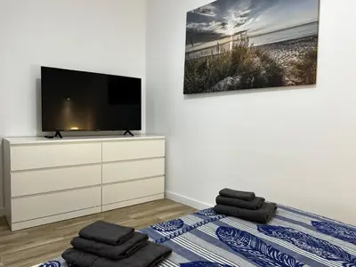 a bedroom with a tv and a bed with towels at Rodrigues 15 in Valencia