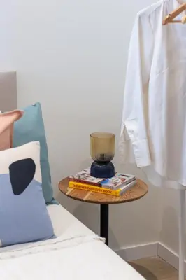 a table with a vase on it next to a bed at VLC HOST - Cubells in Valencia