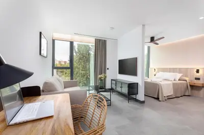 a hotel room with a bed and a living room at Calatrava by Alma Suites in Valencia