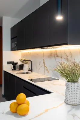 a kitchen with black cabinets and oranges on a counter at Calatrava by Alma Suites in Valencia