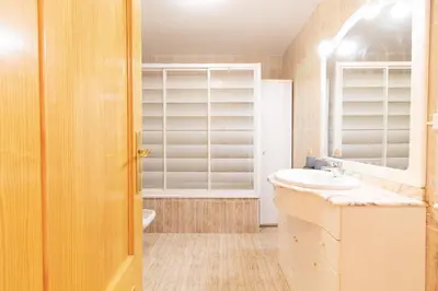 a bathroom with a sink and a toilet and a mirror at Global Vacacional, Apartamento con piscina y terraza en Canet playa in Canet de Berenguer