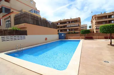 a swimming pool on the side of a building at Global Vacacional, Apartamento con piscina y terraza en Canet playa in Canet de Berenguer