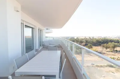 a balcony with a white table and chairs on it at Global Vacacional, Moderno apartamento con dos terrazas con vistas al mar y a la montaña in Canet de Berenguer