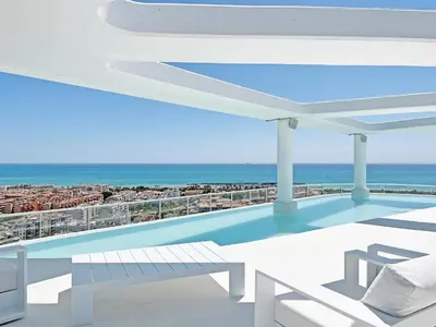 a swimming pool on top of a building with the ocean at Global Vacacional, Moderno apartamento con dos terrazas con vistas al mar y a la montaña in Canet de Berenguer