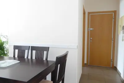 a dining room with a table and a wooden door at Coqueto apartamento de 3 habitaciones by Hometels in Puerto de Sagunto
