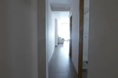 a hallway with white walls and a white tile floor at Coqueto apartamento de 3 habitaciones by Hometels in Puerto de Sagunto