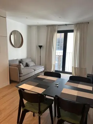 a living room with a table and a couch at Escolano Rooms MAS 11 Noches in Valencia
