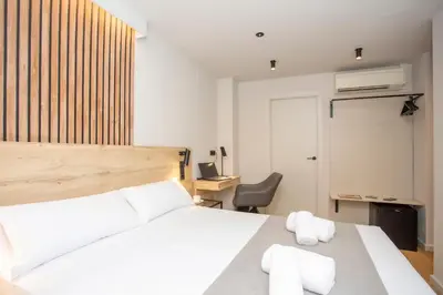 a bedroom with a white bed and a chair at Aila II Hotel Boutique by SingularStays - Digital Access in Burjasot