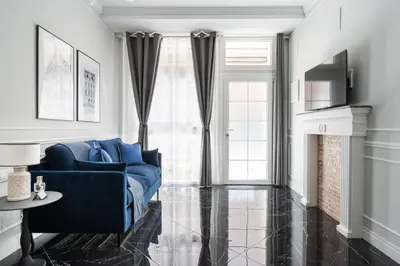 a living room with a blue couch in front of a window at Le Parisien de COUP DE COEUR APPARTEMENTS in Valencia
