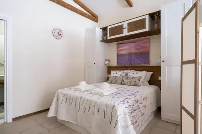 a white bedroom with a bed with white sheets at Le Provençal de COUP DE COEUR APPARTEMENTS in Valencia