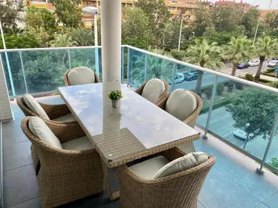 a table and chairs on a balcony with a view at VerdeMar 5 (Playa Puerto de Sagunto) in Puerto de Sagunto