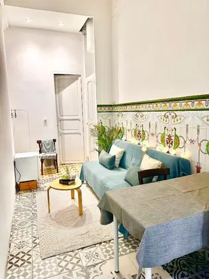 a living room with a blue couch and a table at Habitación doble en Ruzafa con baño privado in Valencia