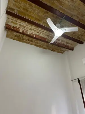 a white ceiling fan hanging from a brick wall at Habitación doble en Ruzafa con baño privado in Valencia