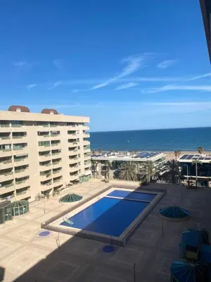 a view of a swimming pool and the beach at Apartamento frente al mar en Playa Patacona in Valencia