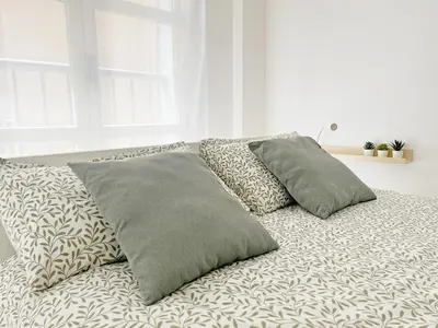 a bed with three pillows on it in a room at Global Vacacional, Apartamento de 3 dormitorios en Sagunto in Sagunto