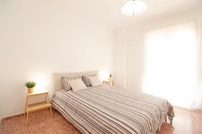 a white bedroom with a large bed and a window at Global Vacacional, Apartamento de 3 dormitorios en Sagunto in Sagunto