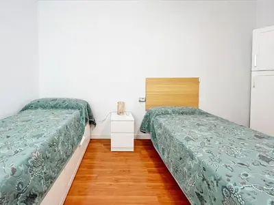 a room with two beds and a room with a mirror at Global Vacacional, Apartamento céntrico de 4 dormitorios in Puerto de Sagunto