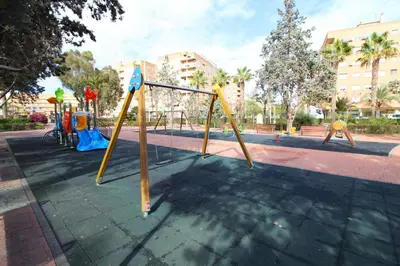 a park with a playground with swings at Global Vacacional, Apartamento céntrico de 4 dormitorios in Puerto de Sagunto