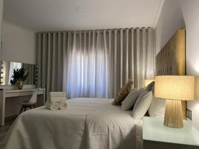 a bedroom with a large white bed and a desk at DON LEONE Hotel in Alginet