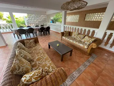 a living room with couches and a dining room with a table at Chalet El Tochar in Valencia