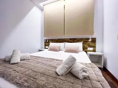a bedroom with a large bed with white sheets and pillows at Baron Suites in Valencia