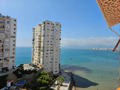 a tall building on the beach next to the ocean at Apartamento a pie de playa I in Faro de Cullera