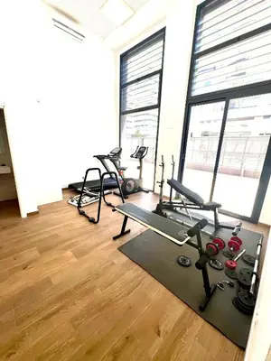 a gym with several treadmills and ellipticals in a room with windows at Dúplex piscina, parking -Roig Arena -Las Ciencias in Valencia