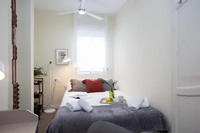 a bedroom with a bed with pillows and a window at SingularStays San Valero in Valencia