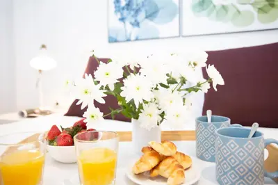 a table with a plate of food and a vase of flowers at SingularStays Gran Via in Valencia