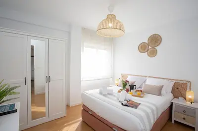 a bedroom with a large white bed with a chandelier at SingularStays Benimaclet in Valencia