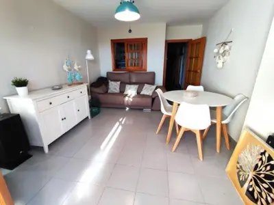 a living room with a table and a couch at Apartamentos Bon Amb in Faro de Cullera