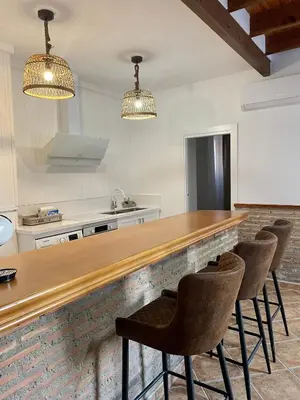 a kitchen with a wooden counter and chairs at UIM Planta baja Canovas del Castillo, PLAYA WIFI in Puerto de Sagunto