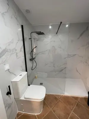 a white bathroom with a shower and a toilet at UIM Planta baja Canovas del Castillo, PLAYA WIFI in Puerto de Sagunto