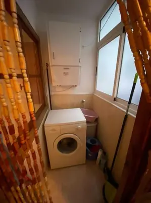 a small bathroom with a washing machine and a window at RIU MAR Apartment Cullera in Cullera