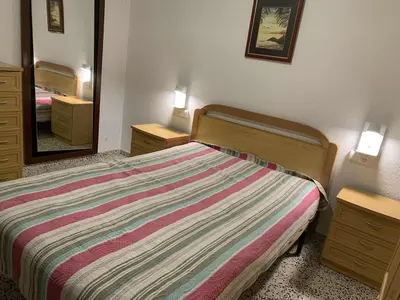 a bedroom with a bed and a large mirror at RIU MAR Apartment Cullera in Cullera