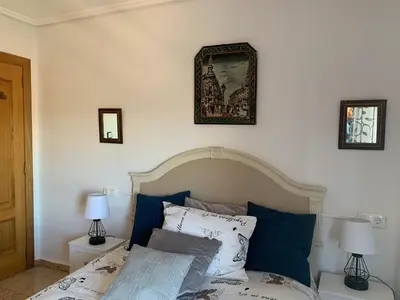 a bedroom with a bed with two lamps and a picture on the wall at Sagunto in Sagunto