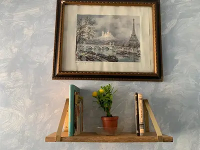 a shelf with books and a picture of the eiffel tower at Sagunto in Sagunto