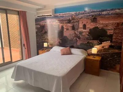 a bedroom with a large painting on the wall at Apartamento Castillo - Alquiler de temporada in Puerto de Sagunto