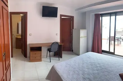 a hotel room with a bed and a desk and a window at Apartamento Castillo - Alquiler de temporada in Puerto de Sagunto