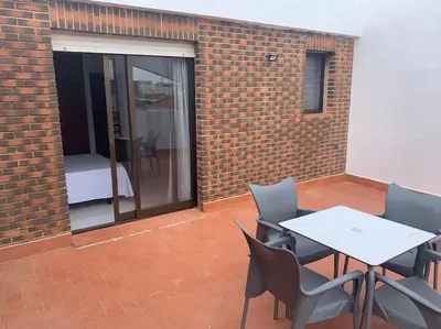 a patio with a table and chairs and a bed at Apartamento Castillo - Alquiler de temporada in Puerto de Sagunto