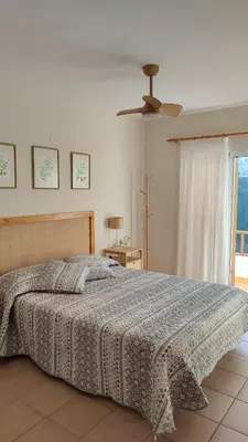 a bedroom with a bed and a ceiling fan at Una casa con vistas in Faro de Cullera