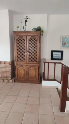 a room with a wooden cabinet and a table at Una casa con vistas in Faro de Cullera