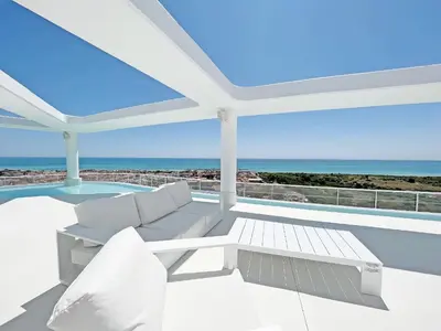 a patio with a couch and a view of the ocean at Global Vacacional, Moderno apartamento con terraza en Gran Canet in Canet de Berenguer