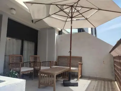 a wooden bench with an umbrella on a patio at Terraced house in natural essence in Favareta